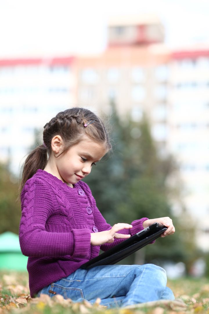 little girl holding tablet...
