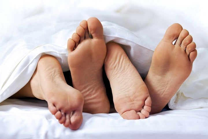 Close-up of the feet of a couple on the bed