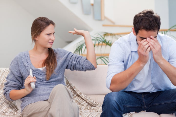 Man being tired of arguing with his wife in their living room