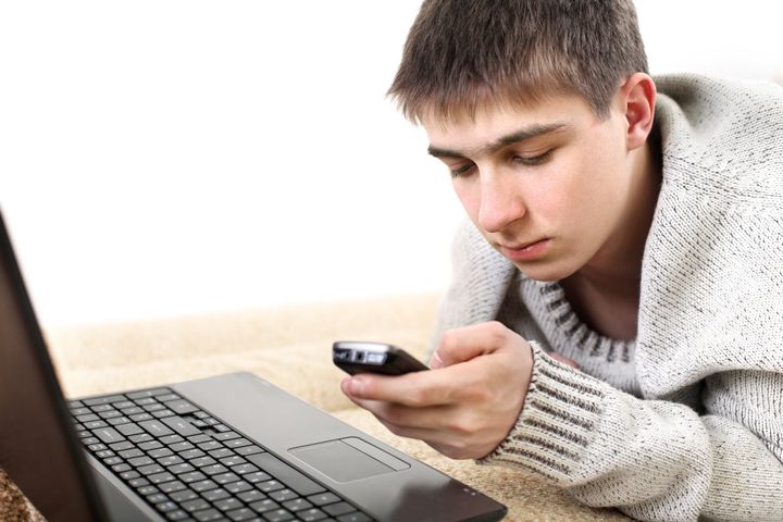 teenager with notebook and mobile phone in home interior