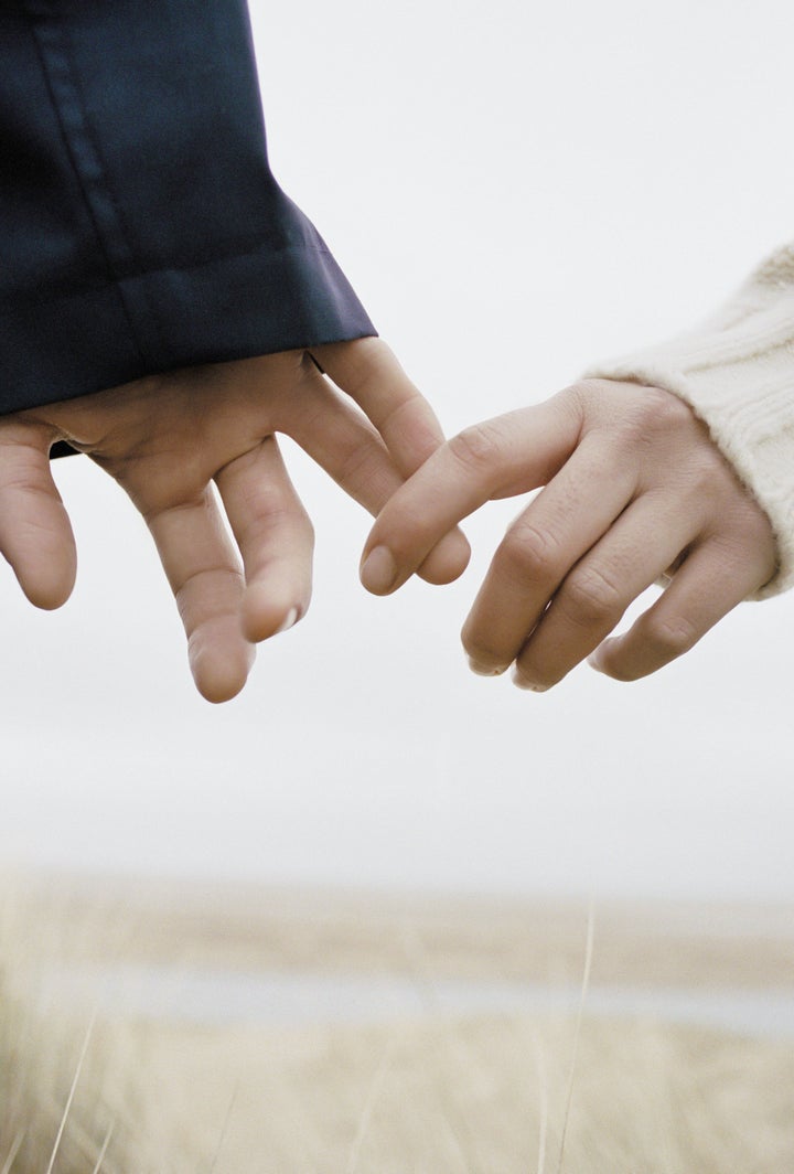 a young couple holding hands, outdoors