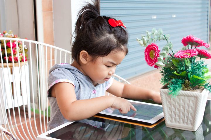 girl pushing tablet on table...