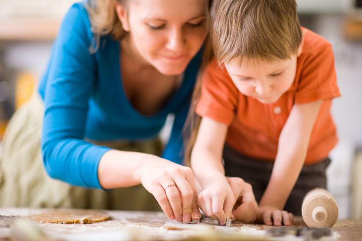 Young mother and son in kitchen making cookies.