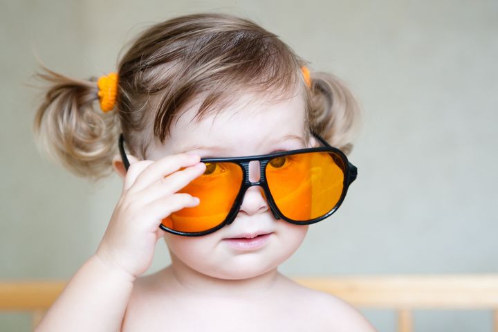 Little cute girl with ponytails and orange sunglasses