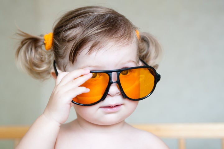 Little cute girl with ponytails and orange sunglasses