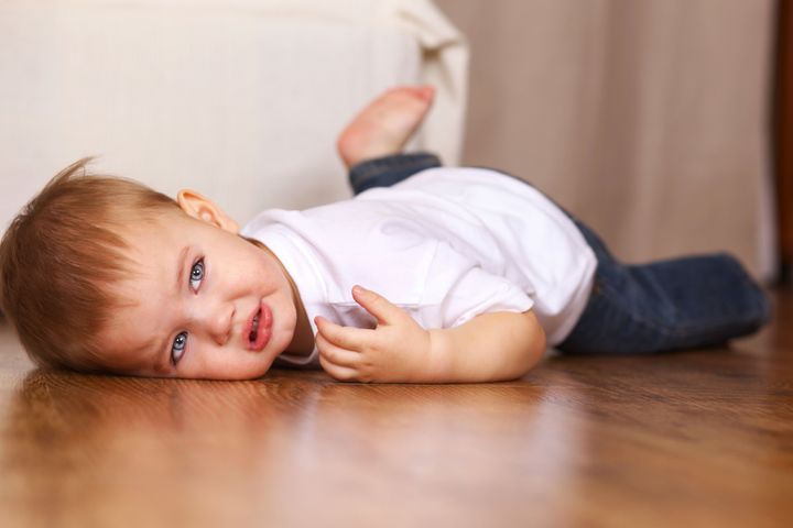 little kid crying lying on floor