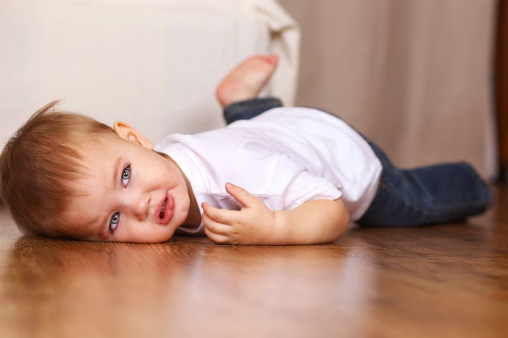 little kid crying lying on floor