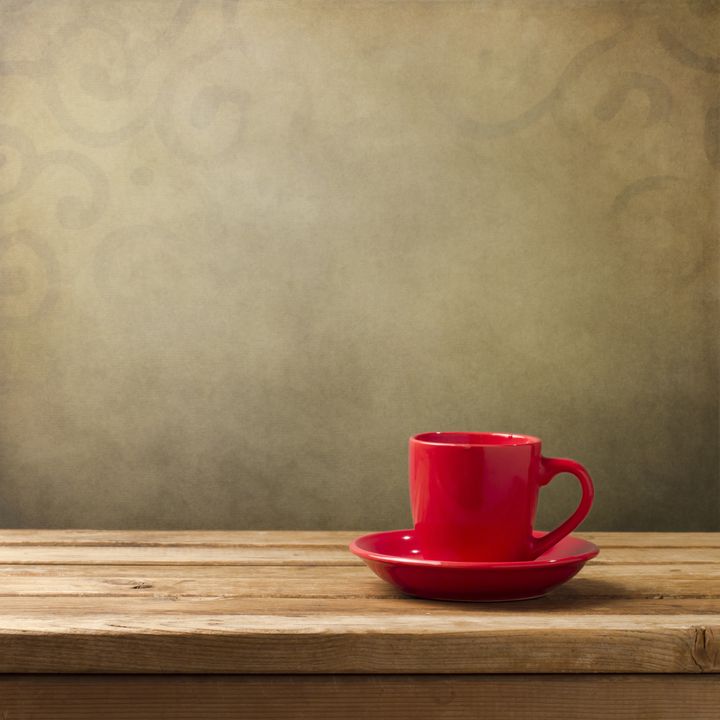 red cup on wooden table over...