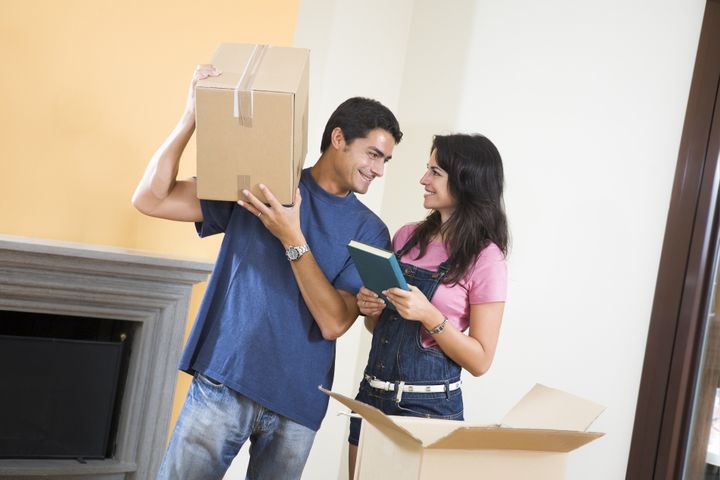 Young happy couple moving boxes at home