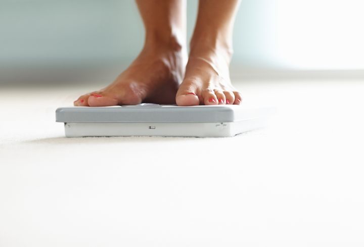 Low section closeup of a woman's feet on weighing scale