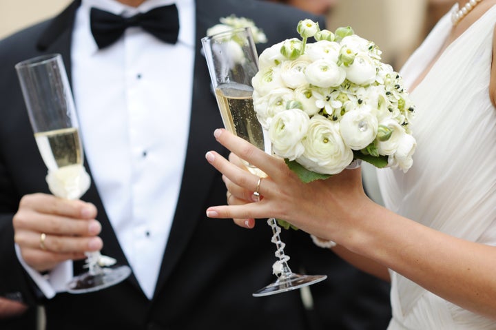 Bride and groom are holding champagne glasses