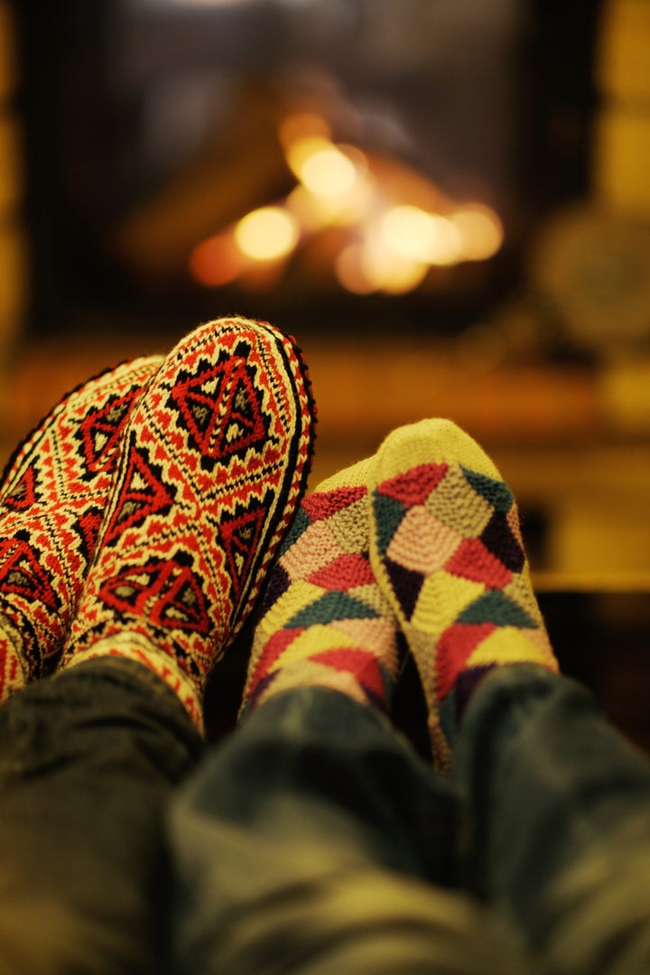 happy Young romantic couple sitting on sofa in front of fireplace at winter season in home