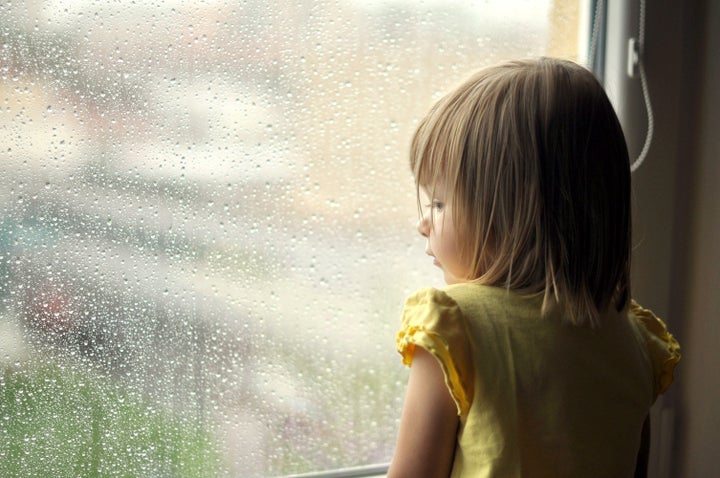 young girl looking from window