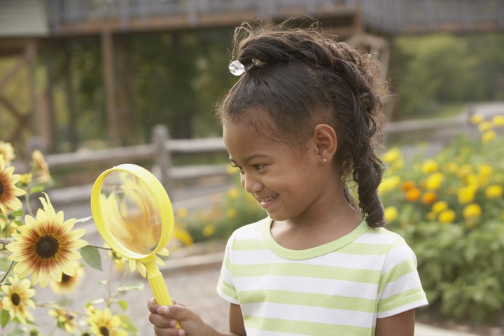 african girl looking at flower...