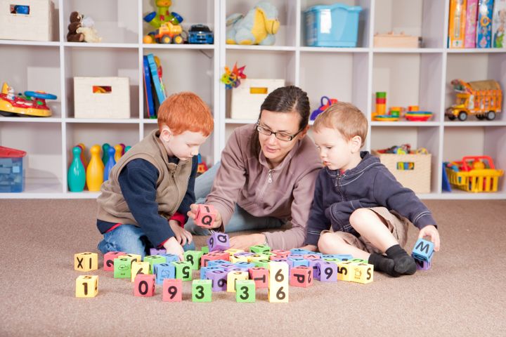 Mother playing blocks games with boys