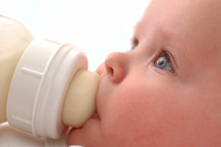 close up of baby drinking his...