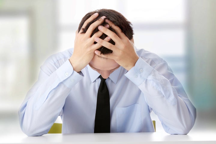 Businessman in depression with hand on forehead