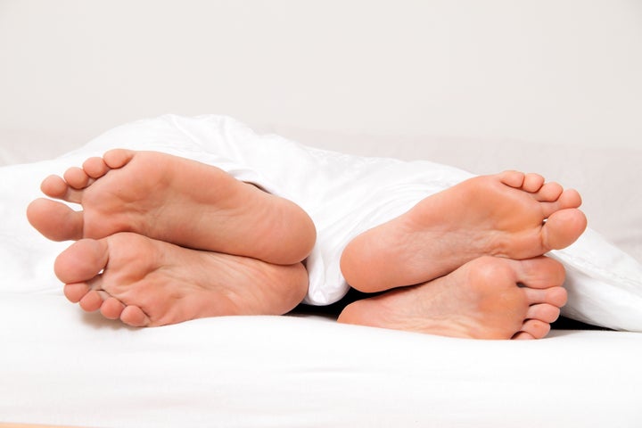 Dier feet of couple in bed. Separation and divorce