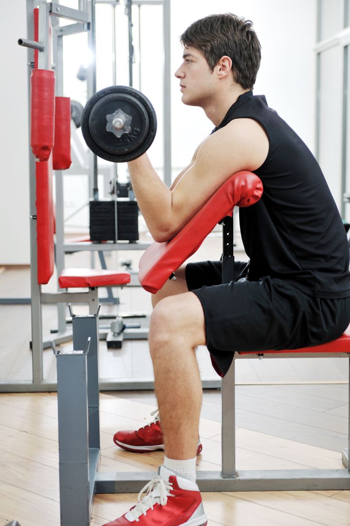 young man in fitness sport club exercise with weights and relaxing