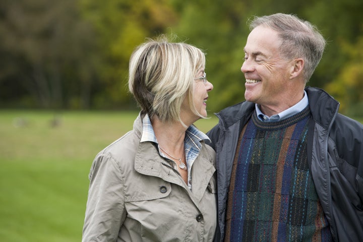 older casual couple sitting in...