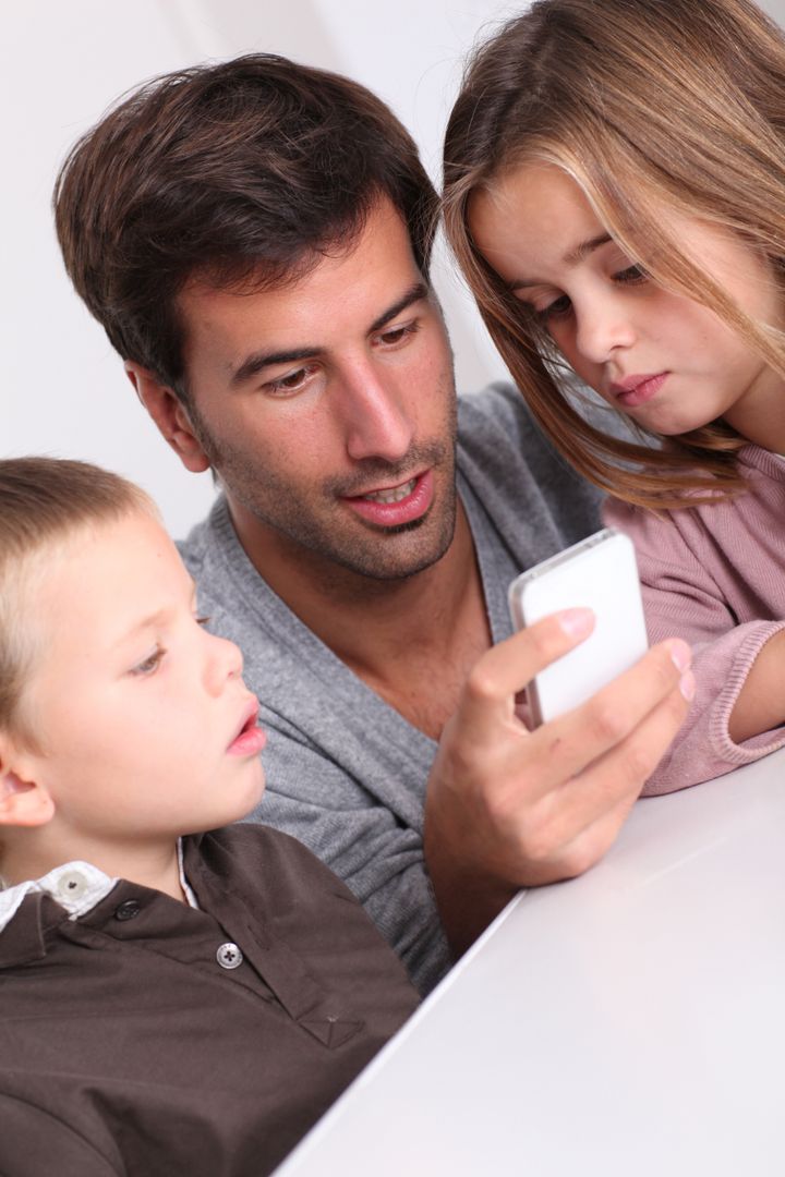 Father and children playing with smartphone