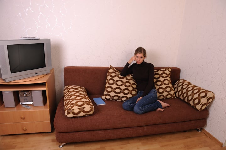 A young and sad woman in a living room