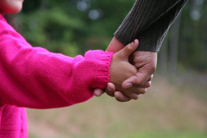 A mixed race mother and daughter holding hands