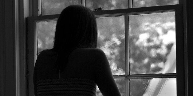 woman looking out window black and white