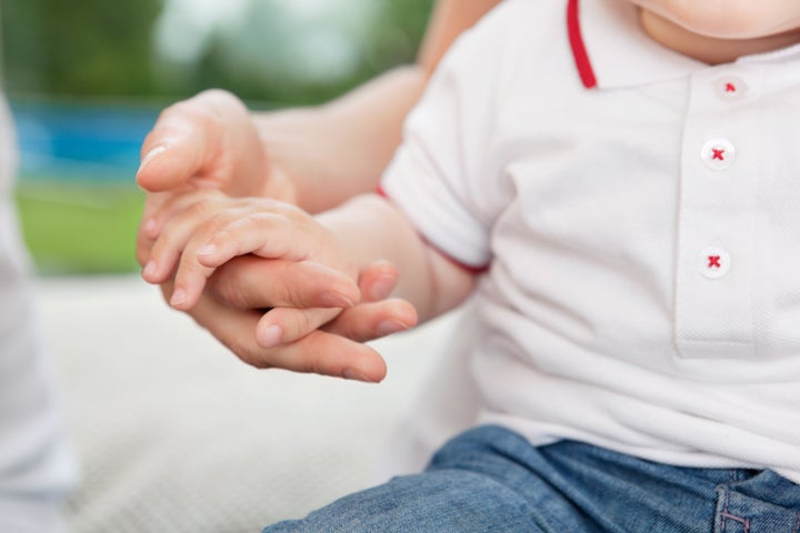 Close-up of mother holding child's hand