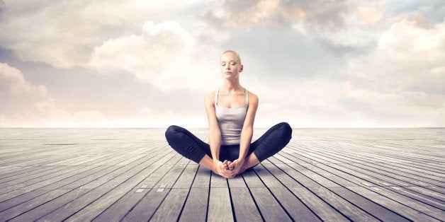 Beautiful woman meditating on a parquet floor