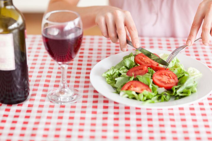 Charming Woman eating lunch and drinking wine in a kitchen