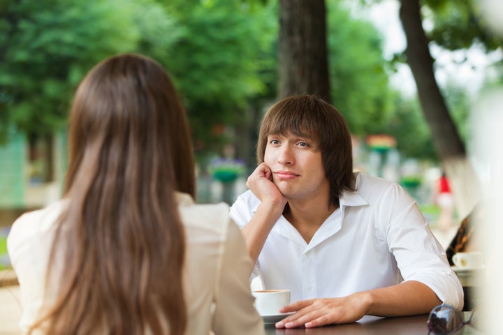 guy is bored on a date with a girl in a summer cafe