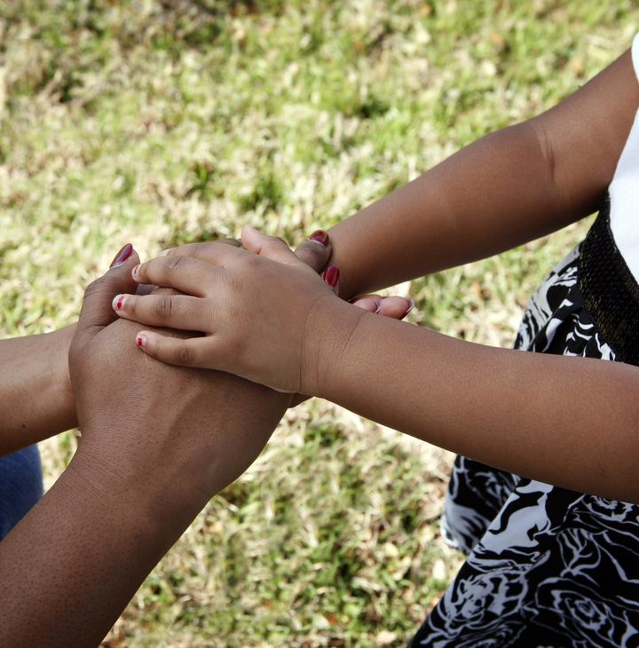 African-American family: mother and child holding hands (grass background)