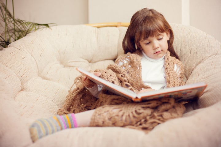 beauty child in shawl reading a ...