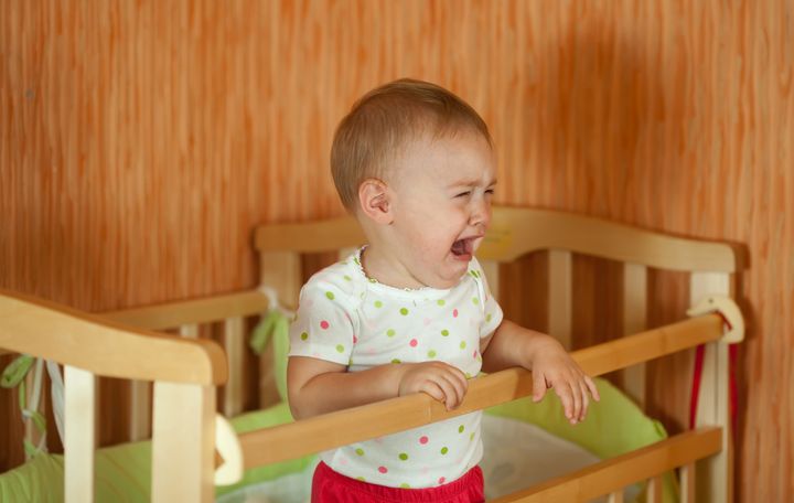 Crying baby of one year old in crib