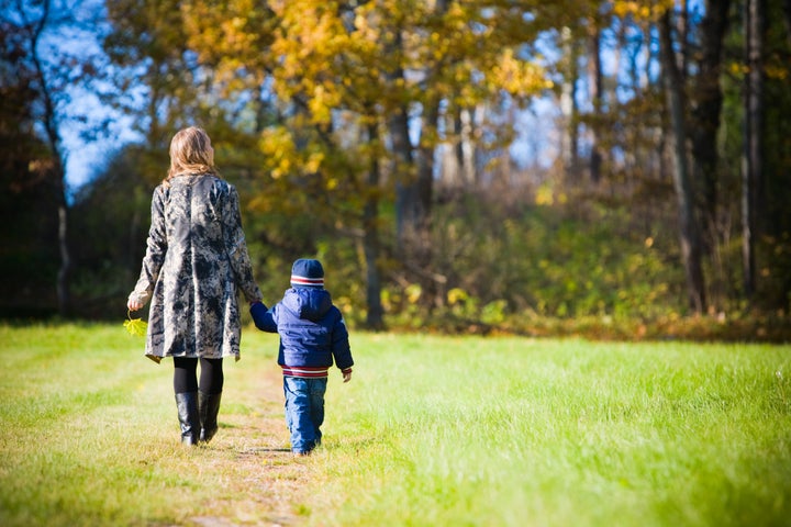 Young mother with son enjoying beautiful autumn day