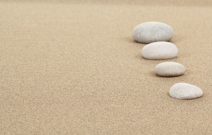 four zen stones in sand as...