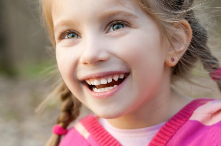 cute little girl smiling in a park close-up