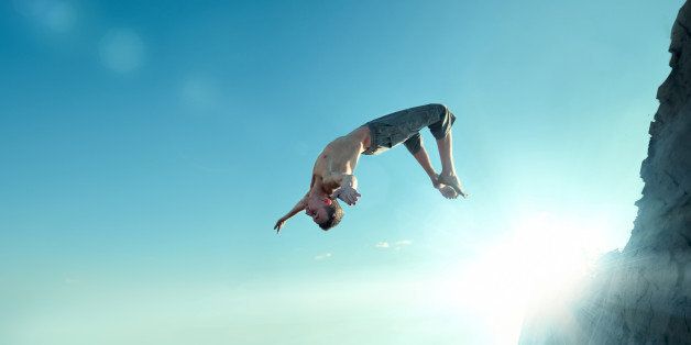 Portrait of an excited young man jumping in air against blue sky
