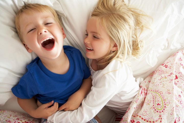 Brother And Sister Relaxing Together In Bed