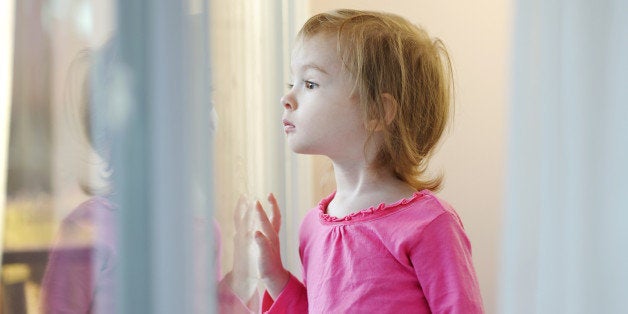 Curious little girl looking out of the window