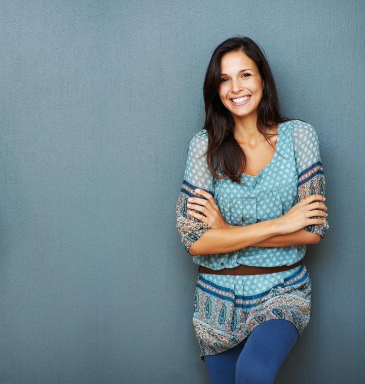 Confident woman with arms crossed against a blue background