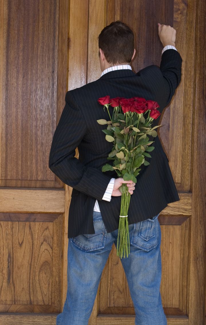 Man knocking on door to present flowers to his date on valentines day