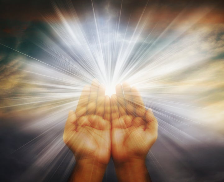 Prayer raised hands on cloudy background