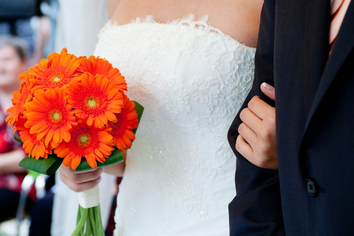 bride with groom holding...