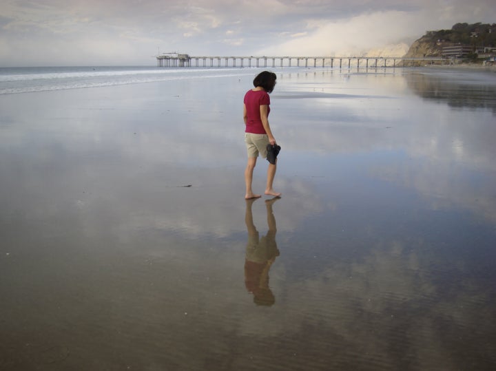 Woman Walking on Mirror Beach. Great for themes of relationships, travel, contemplation, exploration, nature.