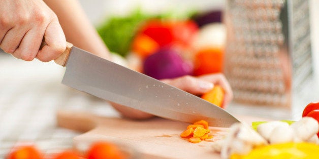 close up of woman cutting vegetables on cutting board