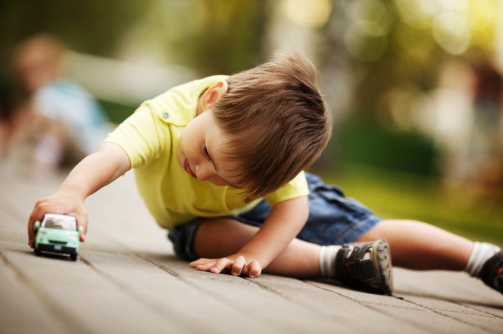 little boy plays with toy car