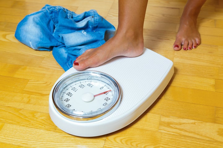 the feet of a woman standing on a bathroom scale