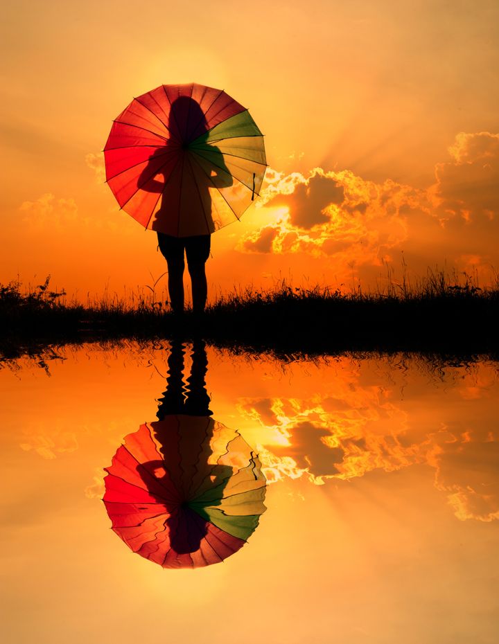 Umbrella woman and sunset silhouette,Water reflection